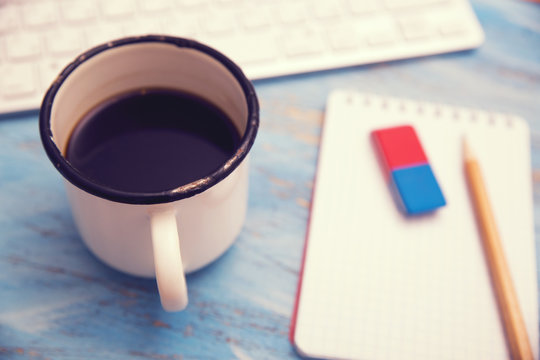 cup of coffee, keyboard and notebook with pencil
