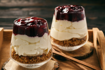 Cheesecake with cherry jelly in glass jars.