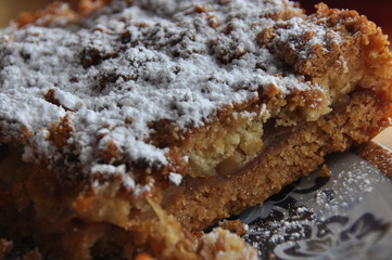 Apple pie dusted with icing sugar on the kitchen table.