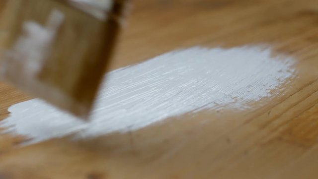 Wood painting with a brush, white color. Close up