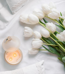 Spring flowers tulips with candles and white pillows