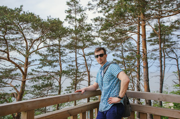 Fototapeta premium man sitting on the wooden stairs in park and smiling