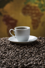 Cup of Coffee and coffee beans / Composition with cup of coffee and coffee beans with a vintage map on the background