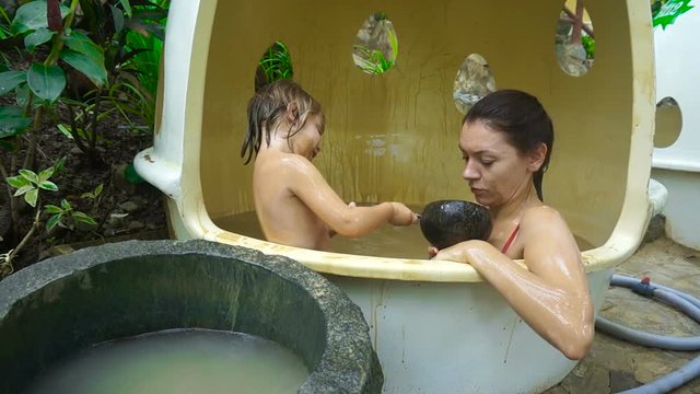 Young mother and three or four year old child swimming in the healing mud bath. The concept of healthy recreation.