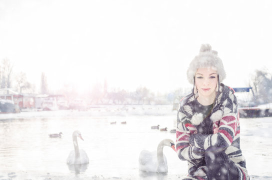 Beautiful Young Girl Crouched On The Icy Say, In The Background