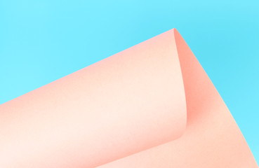 Pink paper rolled on blue background. Abstract texture.