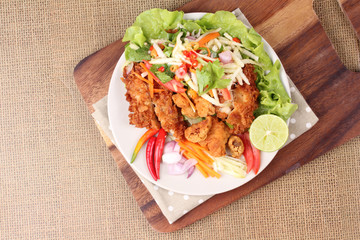 Spicy deep-fried chicken salad with roll green mango .