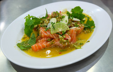 Salmon spicy salad in the white plate, Thailand