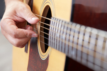 Fototapeta premium Close up of guitarist hand playing acoustic guitar