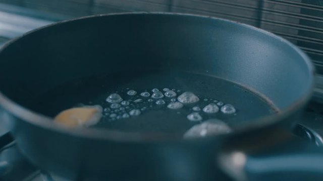 Piece of butter frying in a pan, then somebody pouring scrambled eggs there.