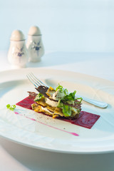 Marinated herring and beet with crispy bread on white plate and white table.