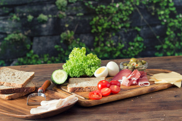 preparing sandwiches with prosciutto, vegetables and spices