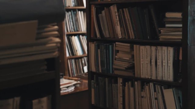 Bookcases full of books and document folders in the old style library. Focus pull