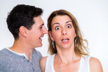 man whisper in the ear of his girlfriend