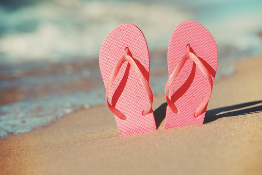 Pink flip flops in the sand on the beach
