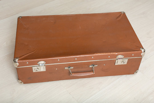 Old suitcase on light background