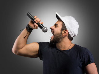 Fototapeta na wymiar Young man singing into a microphone