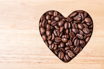 Heart shaped coffee beans on wooden board