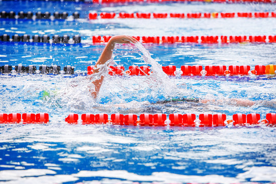 Backstroke swimmer with splash, motion blur on swimmer, focus on