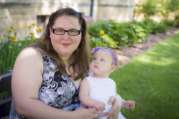 Happy mother and daughter together in the park on summer day