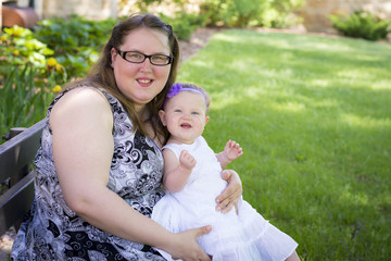 Happy mother and daughter together in the park on summer day
