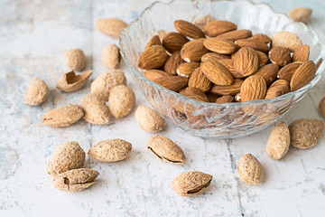  Almonds.   Almonds, peeled kernels in a glass vase and whole nuts on  old wooden table.