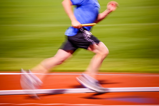Blurred motion image of a man running in a relay race,
