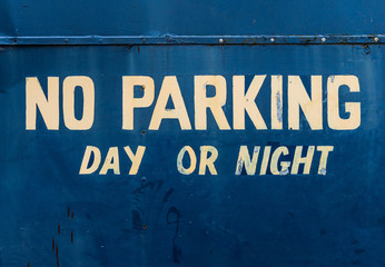 no parking sign on blue metal gate