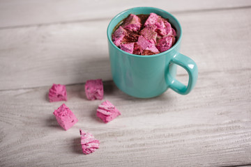 Latte with pink marshmallow. Winter drink theme. Blue cup of hot cocoa with pink marshmallows. Hot chocolate with marshmallows spices. Coffee, cocoa. Christmas Still Life