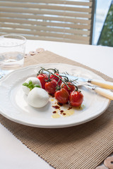 Tomato and mozarella salad on a white plate.