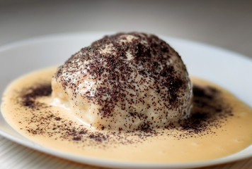 Steamed Sweet Austrian Dumplings Germknodel with chocolate filling and cowered with vanilla sauce sprinkled with poppy seeds