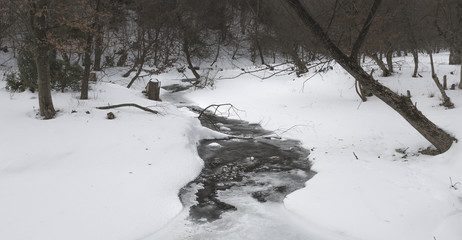 Aerial view over a frozen creek during winter