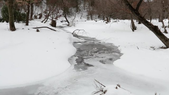 Aerial view over a frozen creek during winter