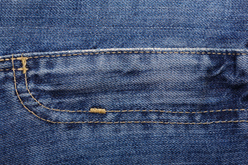 Fototapeta premium Denim jeans texture background with torn. The texture of the colored cotton fabric. Stitched texture jeans background. Fashion jeans button. Pocket and rivet on jeans. Fiber and fabric structure.