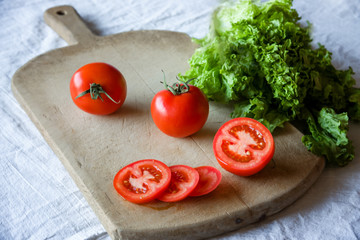 Tomatoes and lettuce on a wooden background.