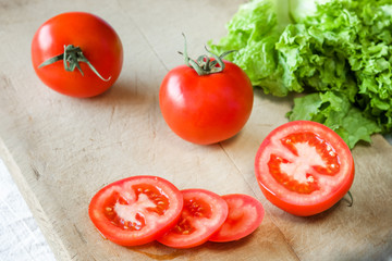 Tomatoes and lettuce on a wooden background.