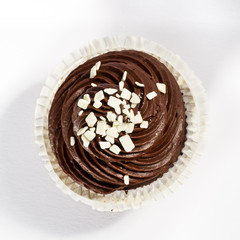 chocolate frosted cupcake with white chocolate decoration, view from above