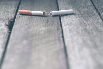 broken cigarette on a wooden background