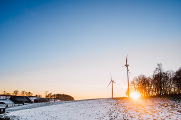 Windkraftanlagen in der Wintersonne/Verschneite Wiese mit Windrädern