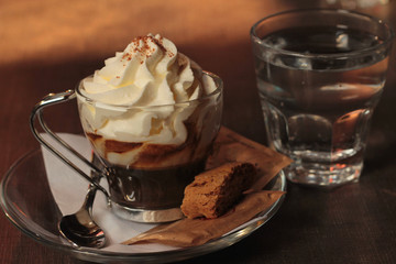 cup of coffee served with biscuits and a glass of water