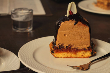 chocolate sponge cake desert served on a white plate with a glass of water