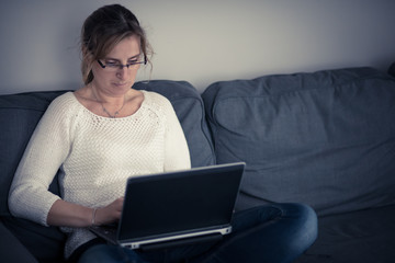 Middle-aged woman using laptop at home