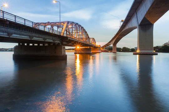 Fototapeta Steel bridge crossing Bangkok river night view, Thailand