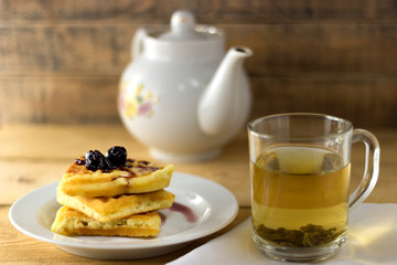 Green tea in a transparent mug with waffle