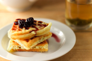 Green tea in a transparent mug with waffle