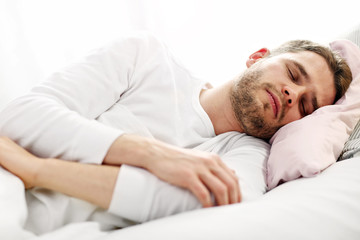 Obraz na płótnie Canvas Young man sleeping in bed