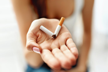 Woman Hand Showing Broken Cigarette. Unhealthy Lifestyle