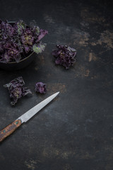 Obraz na płótnie Canvas Flower Sprout in einer Schüssel und einem Messer auf einem alten rostigen Untergrund