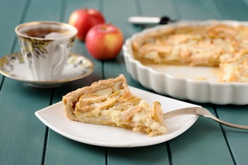 Apple tart with cup of tea and whole apples
