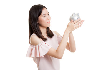 Young Asian business woman kiss  a pink coin bank.